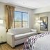 Red Roof Inn & Suites Fayetteville-Fort Bragg room with sofa, window view, and wall-mounted TV