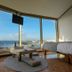 Viewtower Resort in Jeju City room with panoramic ocean view, low table, cushions and bed by windows