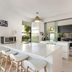 Metzo Noosa Resort in Noosa Heads: bright suite kitchen with island seating and sliding doors to a bedroom