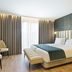 Acta The Avenue in Porto room with king bed, tufted headboard, bench, and floor-to-ceiling curtains