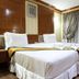 Ao Nang Beach Resort in Krabi guest room with two twin beds, wood-paneled walls and draped curtains