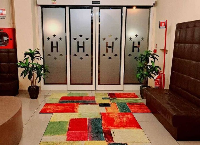 Hotel Laguna Residence Venice lobby with frosted glass doors, colorful rug, potted plants and seating