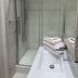 The Anchorage & The Tackleshed, Barry: modern glass walk-in shower with folded towels beside a sink