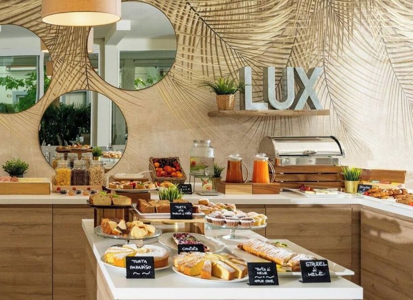 Hotel Lux Gabicce Mare breakfast buffet with pastries, fruit, juice, and coffee station