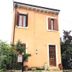 Casa Perlar in Verona, peach-colored hotel exterior with shutters, front door, and small garden gate