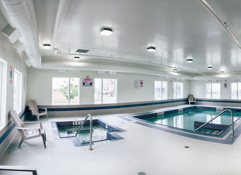 Motel 6 Airdrie Ab indoor pool with hot tub and seating area in Airdrie