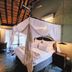 La Lechere Guest House in Phalaborwa, canopy bed in a rustic room with tiled floor and seating area