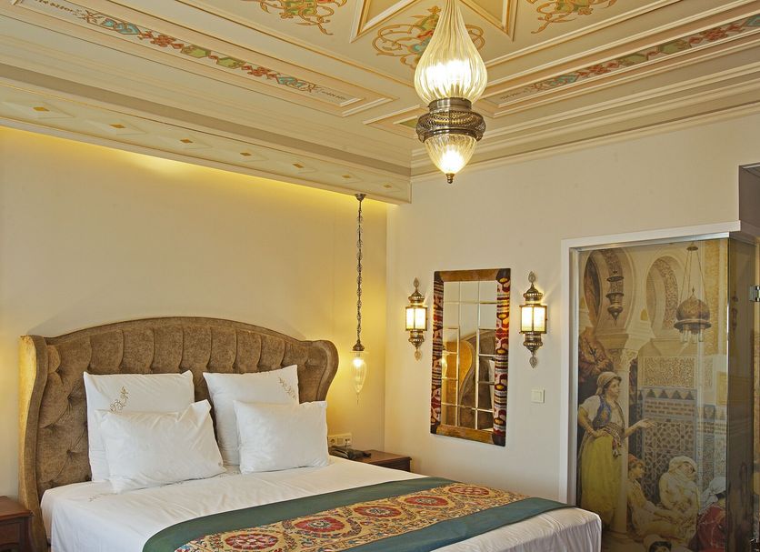 Azade Premier Hotel in Istanbul room with ornate ceiling, tufted headboard, and hanging lanterns