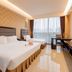 Aimoer Hotel Foshan guest room with two beds, desk, and large window with city view