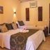 Pousada Villa Das Pedras room in Pirenópolis with two beds, wall art, and tiled floor