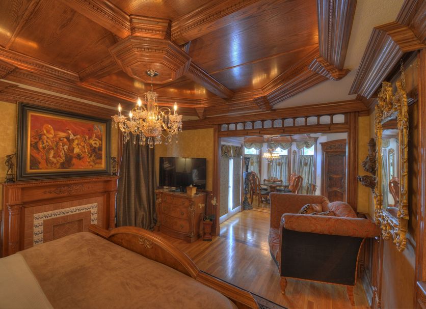 The Victoria Bed & Breakfast in Bentonville: ornate wood-paneled guest room with chandelier and sitting area