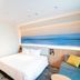 Richmond Hotel Miyazaki Ekimae room with bed, city-view artwork, and seating area in Miyazaki
