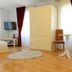 Villa Olivia, Split: bright room with wardrobe, TV, chair, small table, sofa and red curtains