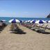 Tigullio Camping & Resort in Sestri Levante beach with rows of blue-and-white umbrellas and loungers