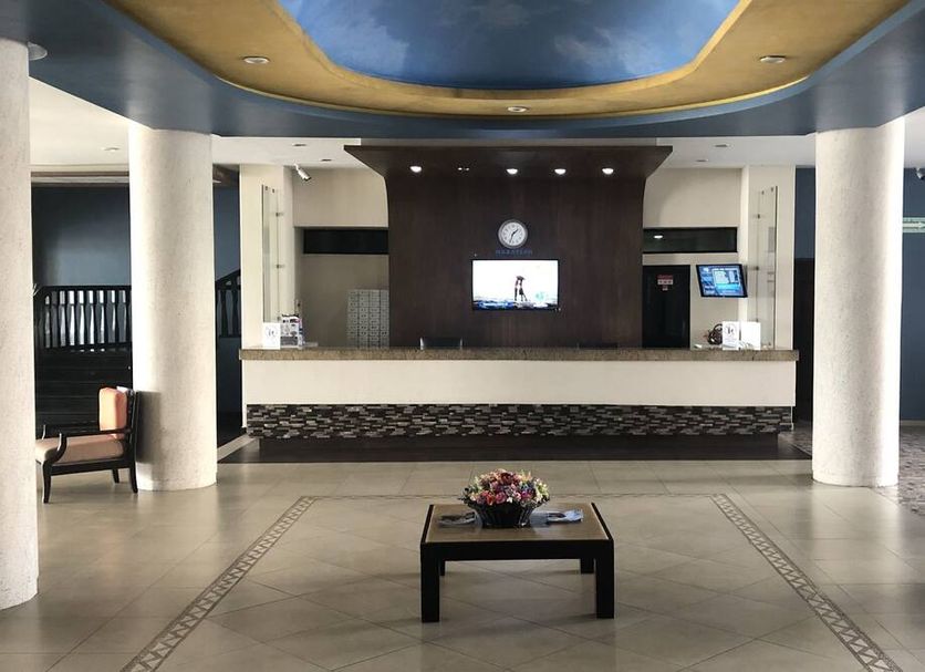 Hotel Playa Bonita lobby in Mazatlán with front desk, white columns and a central seating table