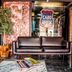 Ocean Suites Santa Maria lobby with leather sofa, plant, and colorful wall art