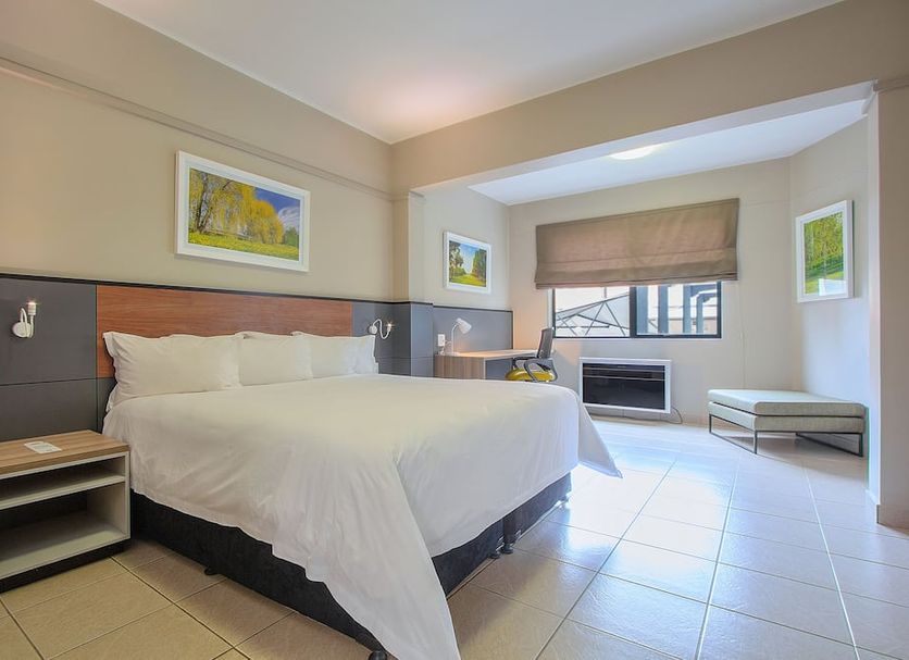 The Park Lodge Hotel Pretoria guest room with king bed, window seat and tiled floor