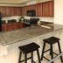 Crystal Towers Gulf Shores kitchen with granite breakfast bar and black stools