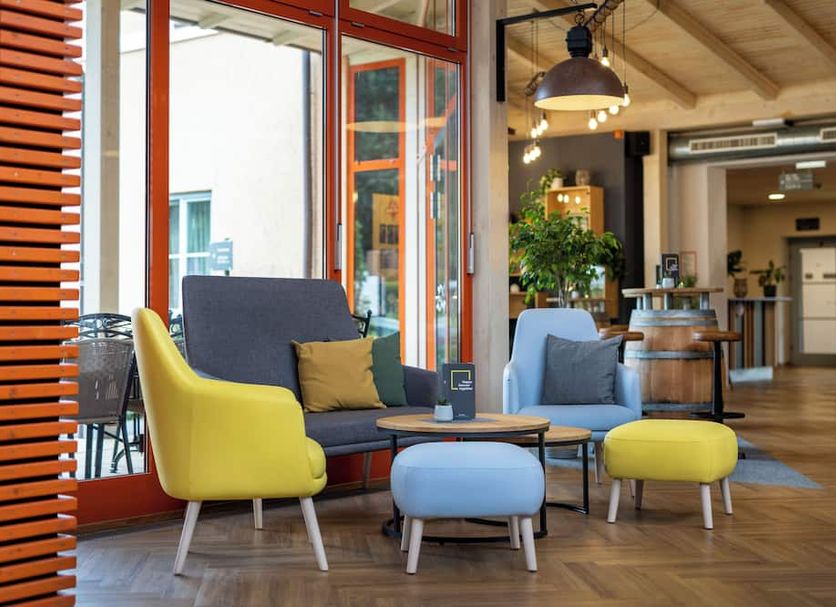 Hotel Jufa Deutschlandsberg lounge with colorful chairs and seating area in Deutschlandsberg