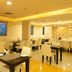 Ginger Jaipur in Jaipur restaurant with tables, white chairs, and large windows