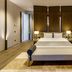 Kaya Palazzo Golf Resort Belek guest room with king bed, bedside lamps, and modern seating