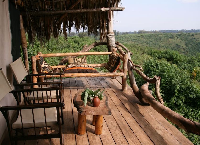 Crater Forest Tented Camp in Karatu: rustic tented deck with chairs and forest valley views