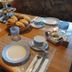 Breakfast table setting at Pension zum Mühlrad in Millstatt with bread basket, cups, plates and utensils