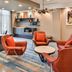 Fairfield Inn and Suites by Marriott Raleigh Cary lobby seating area with orange chairs and modern decor