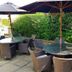 The Carpenters Arms Bristol outdoor patio with tables, wicker chairs and large umbrellas