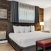 Lake Placid Inn: Residences guest room with king bed, bench, and vanity bathroom in Lake Placid