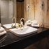 Hôtel Lac Carling Golf & Spa bathroom with black countertop, vessel sink, gold faucets, and glass shower, Grenville