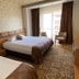 Sor Hotel Eskisehir guest room with two beds, patterned carpet and a window with chairs in Eskişehir