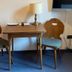 Bayerischer Hof, Münnerstadt: small table with lamp and two wooden chairs in a guest room