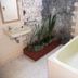 Bathroom at Bali Lovina Beach Cottages in Buleleng with a bathtub, sink, and indoor planter
