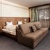 Pension Kreuzjoch in Zell am Ziller, room with double bed, sofa, desk and large window curtains