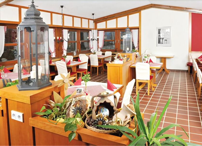 Landhotel Christopherhof in Grafenwiesen dining room with set tables, tiled floor, and wood-framed windows