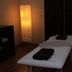 Massage treatment room at Przylądek Daglezja nad Jeziorem Kórnickim in Kórnik with a treatment bed and floor lamp.