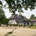 Hotel Waldesruh Am See in Aumühle, exterior with timber-framed building and tree-lined grounds