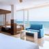 Playasol in Roquetas de Mar: bright sea-view room with balcony, blue sofa, and bathtub