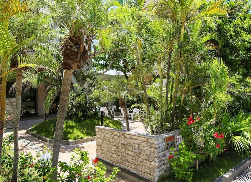 Route Inn Grantia Ishigaki garden courtyard with palm trees and stone planter in Ishigaki
