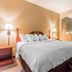 Quality Suites New Iberia guest room with king bed, lamps, chair and coffee table