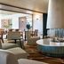 The Relais Cooden Beach lounge in Bexhill-on-Sea with circular fireplace, seating and bookshelves