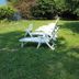 Hotel Glavjc, Torno: white lounge chairs on a grassy garden lawn