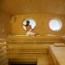 Strandhotel Dünenmeer in Ostseebad Dierhagen: sauna interior with woman by circular windows