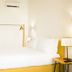 Bo - Álvares Cabral Guesthouse in Porto, minimalist guest room with a white bed and stone accent wall