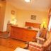 Ard na Breatha in Donegal bedroom with wooden bed, plaid armchairs, and warm yellow walls