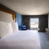 Bally's Baton Rouge Hotel guest room with king bed, TV, and city view from window