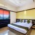 Hotel Golden Treat Indore room with double bed, window view, desk and wall-mounted air conditioner