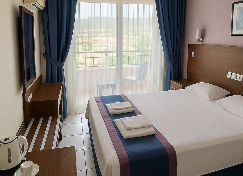 Doruk Hotel & Suits in İçmeler room with double bed, balcony doors, and sea or garden view