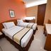 Hotel Nyland Pasteur Bandung room with two twin beds, TV, and simple seating in Bandung